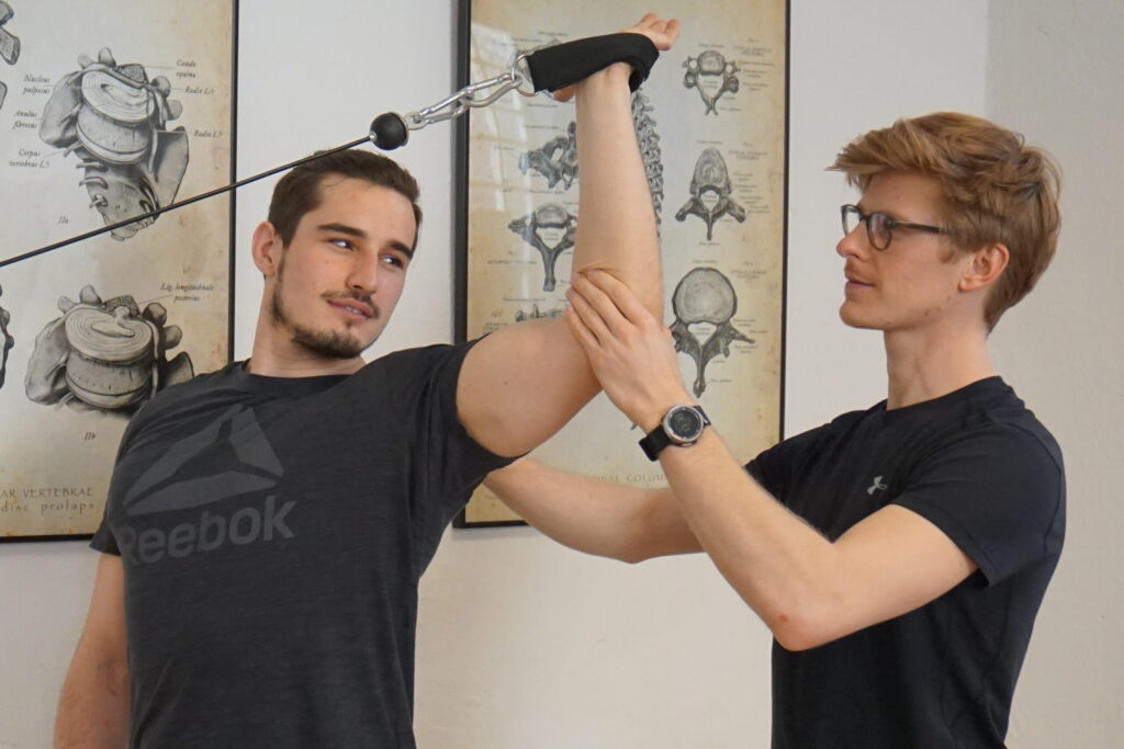 Physiotherapeut Aaron Sehn behandelt die Schulter eines Patienten
